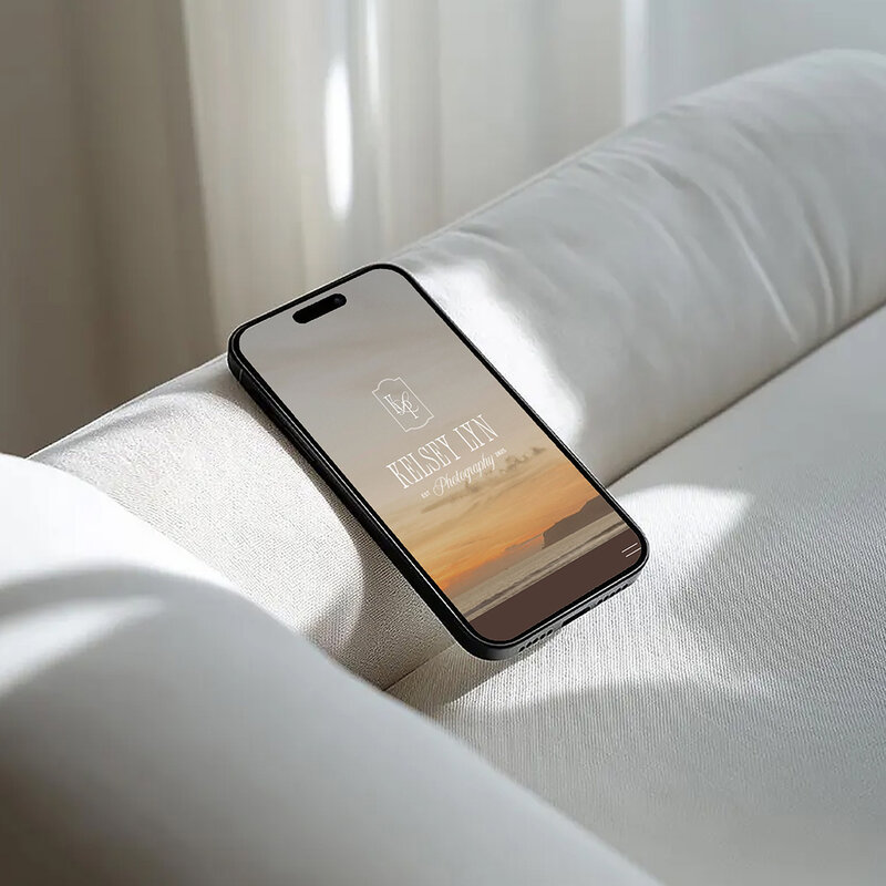 iPhone mockup displayed on a cozy sofa, showcasing a family photography website design.