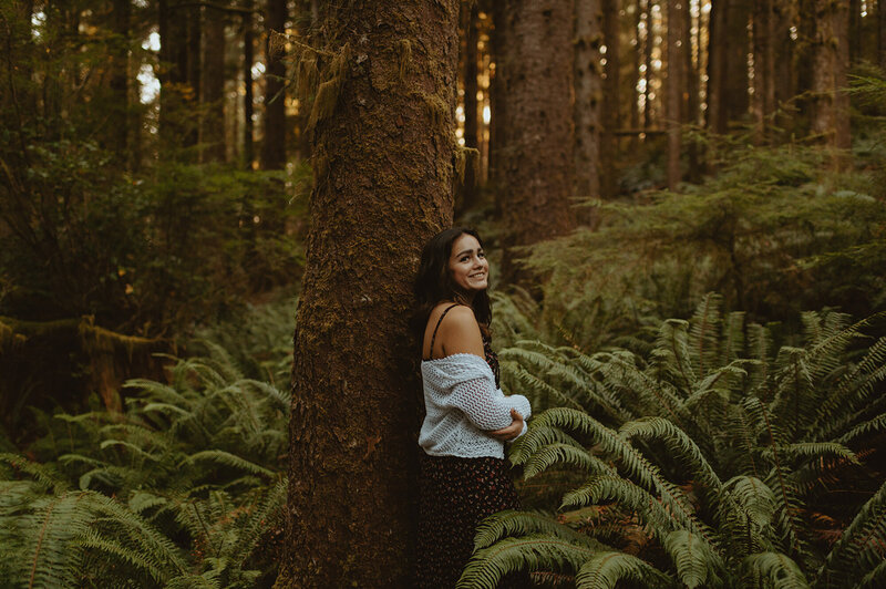 girl leaning against a tree in the woods
