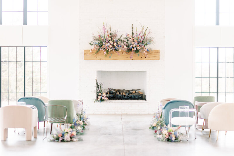 wedding ceremony in a white room with a fireplace