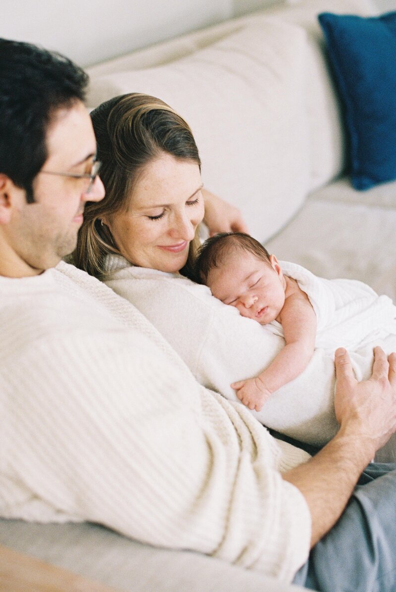 Kaitlin and her husband cuddling with their newborn baby