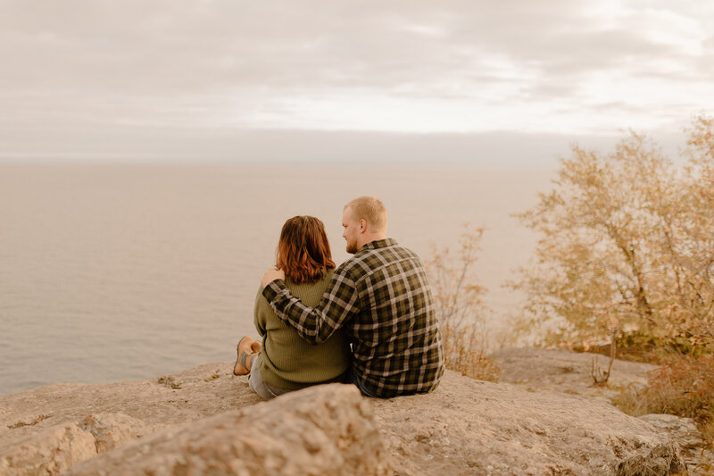 Couple sitting on cliffside over water