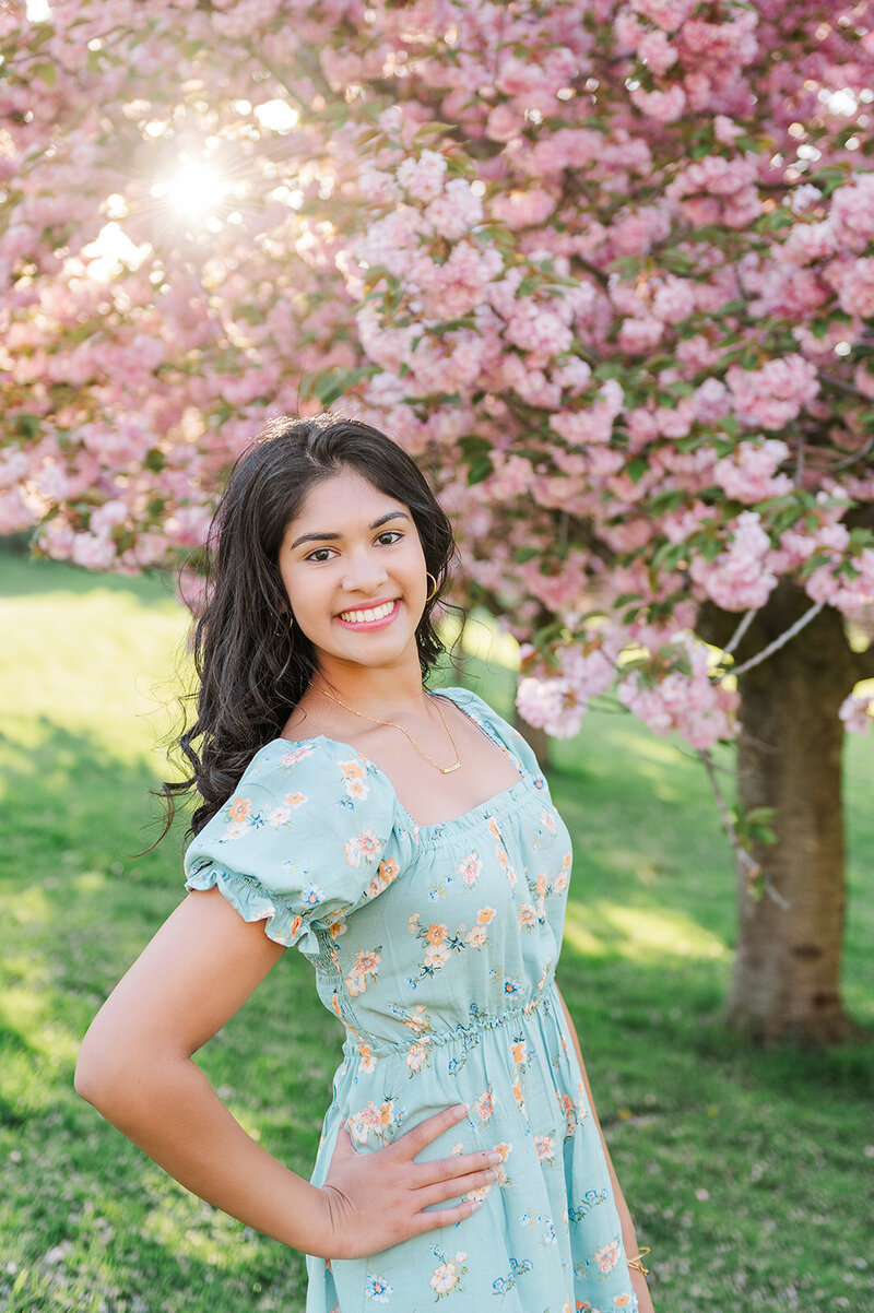 Senior girl in a light blue dress posing in front of Cherry Blossom's by York PA photographer