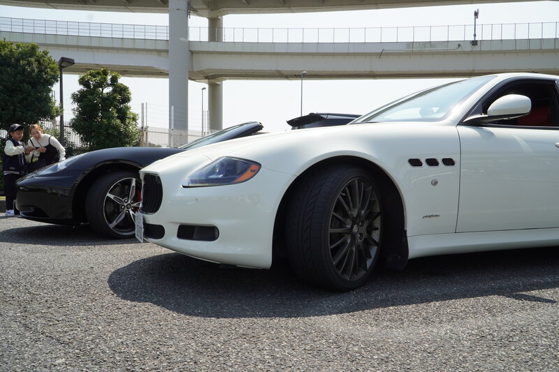 Front angle of a white Maserati Quattroporte GTS parked at a Tokyo highway rest stop, highlighting its sleek body lines, black rims, and performance aesthetic from the Tokyo Luxe Drive collection.