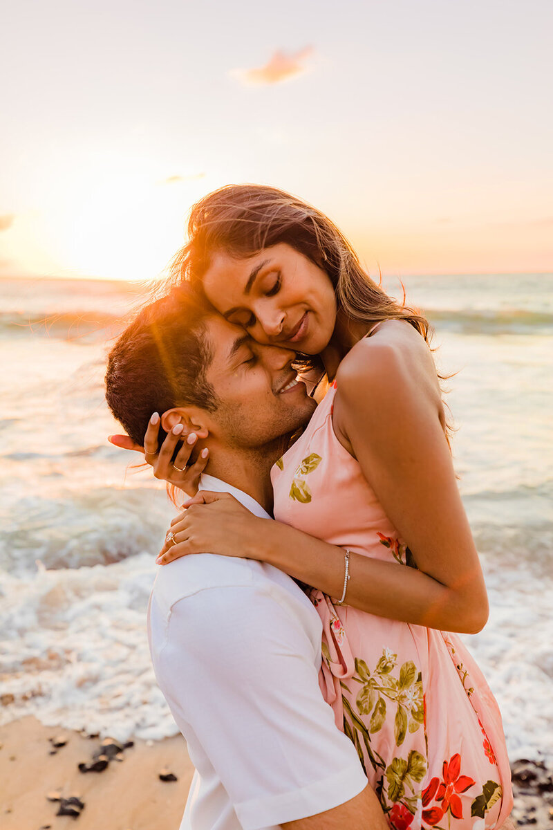 woman and man cuddling at sunset at a wailea beach with love and water