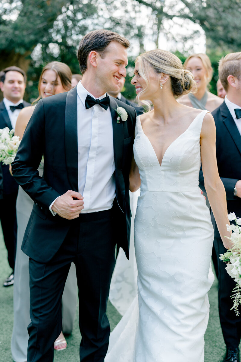 Bride and groom walking with bridal party in the garden at William Aiken House. Blonde bride.