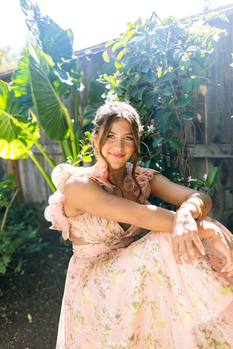 brunette girl with colored eyes in whimsical dress posing in a garden