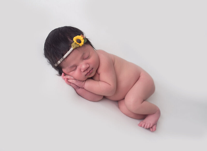 Newborn portrait in sunflower headdress by Laura King