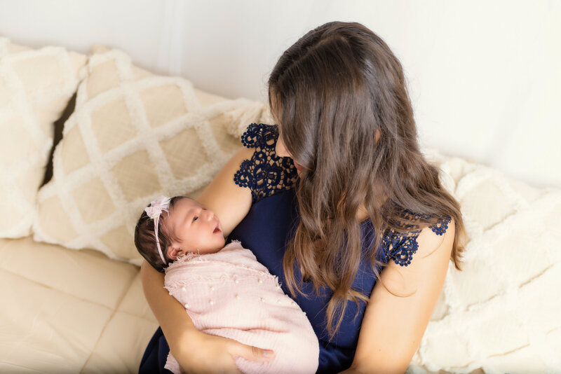Newborn Photographer,  a young mother holds and admires her baby girl