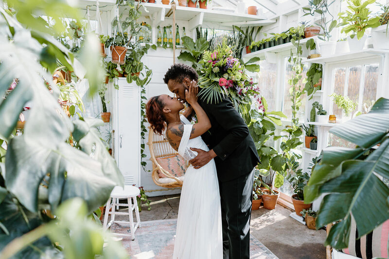 newlyweds kissing in green house