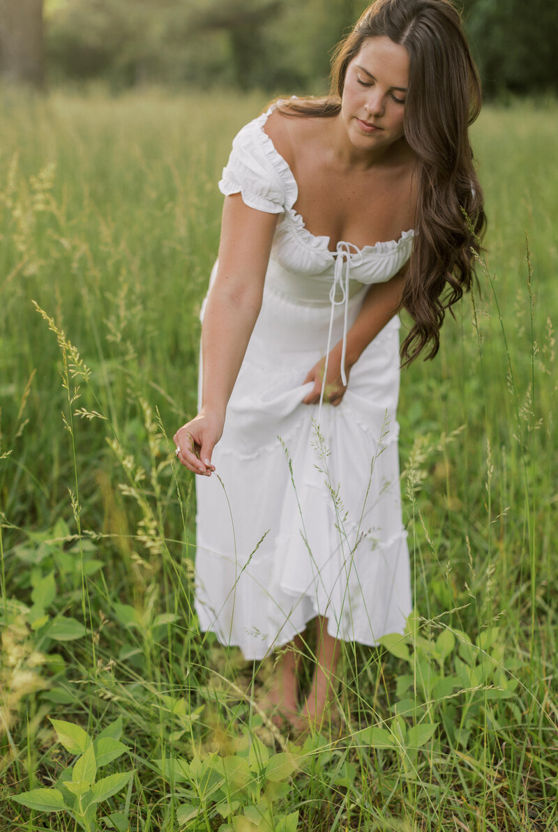A girl taking pictures in a field in a white dress in Southern California.