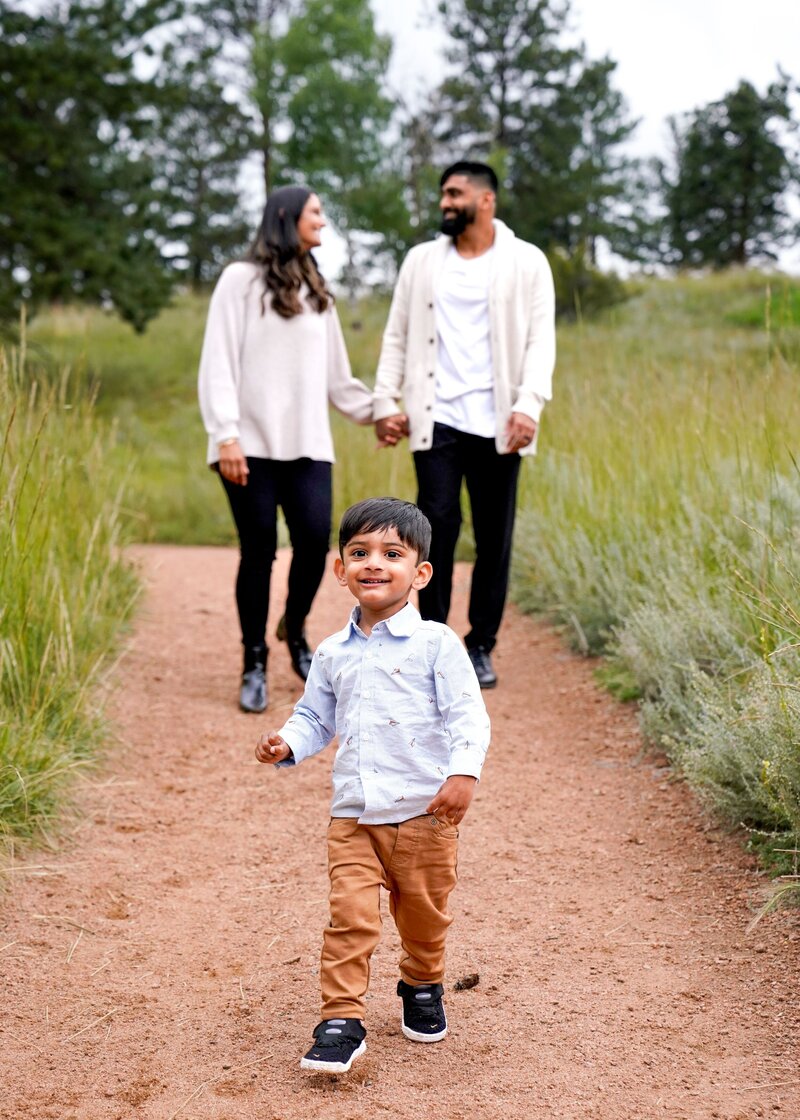 parents walking behind young boy