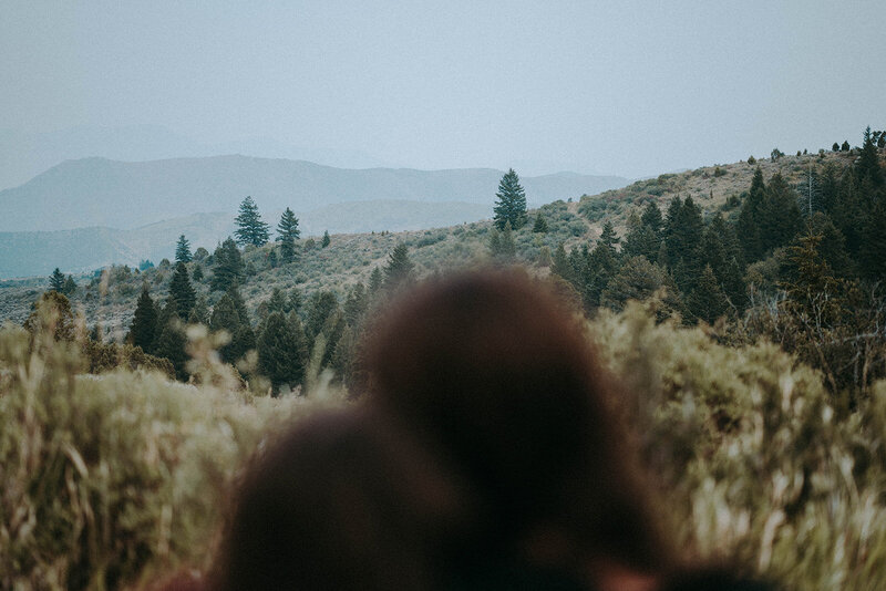 A film photo of the silhouettes of a couple with the rolling Idaho hills in the background.