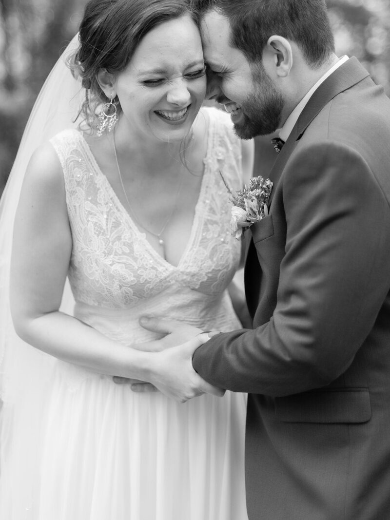 A-black-and-white-photo-of-a-bride-and-groom-laughing