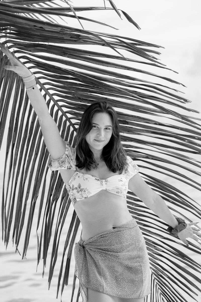 Alyssa Dougherty at the beach with a palm leaf