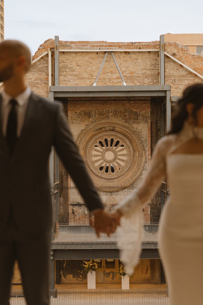 bride and groom hold hands at wedding venue in phoenix arizona