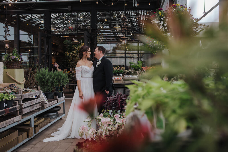 A newlywed couple standing close and about to kiss