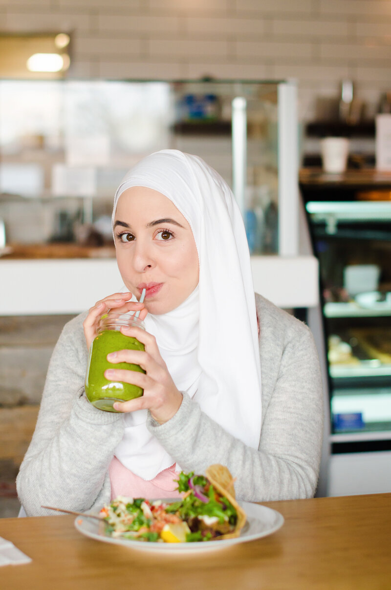 Fitness hijabi coach Hanan drinking a green smoothie