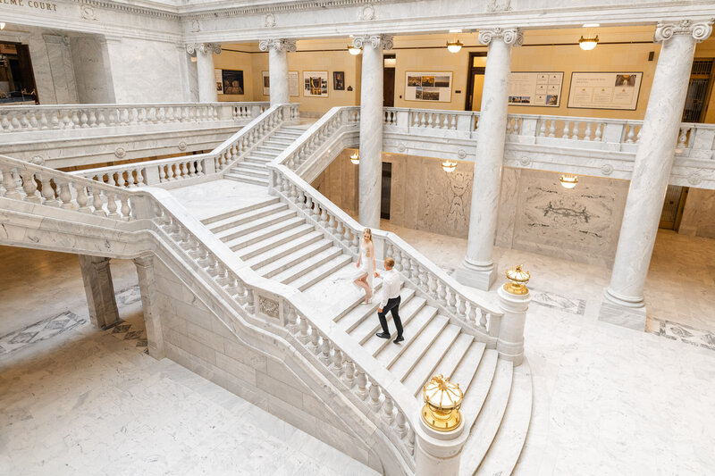 A couple walking up the grand staircase at the Utah State Capitol building