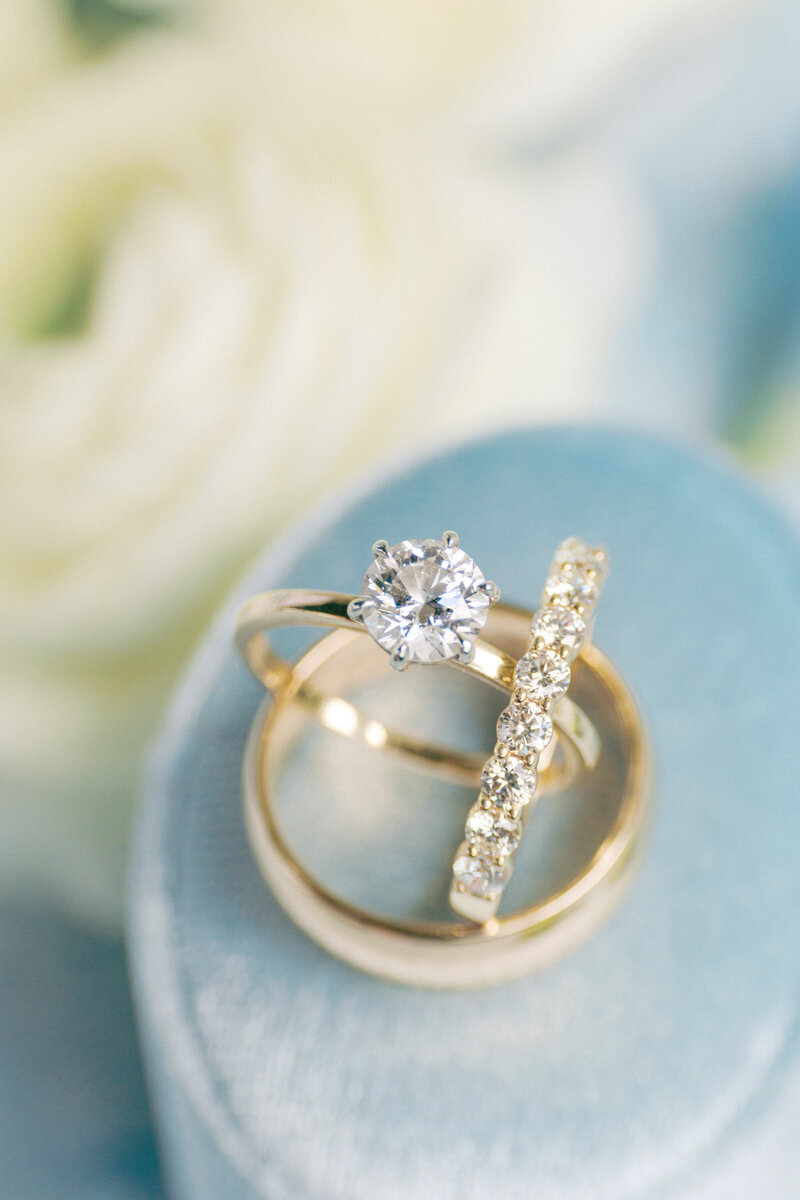 Wedding details flat lay on blue background with white flowers