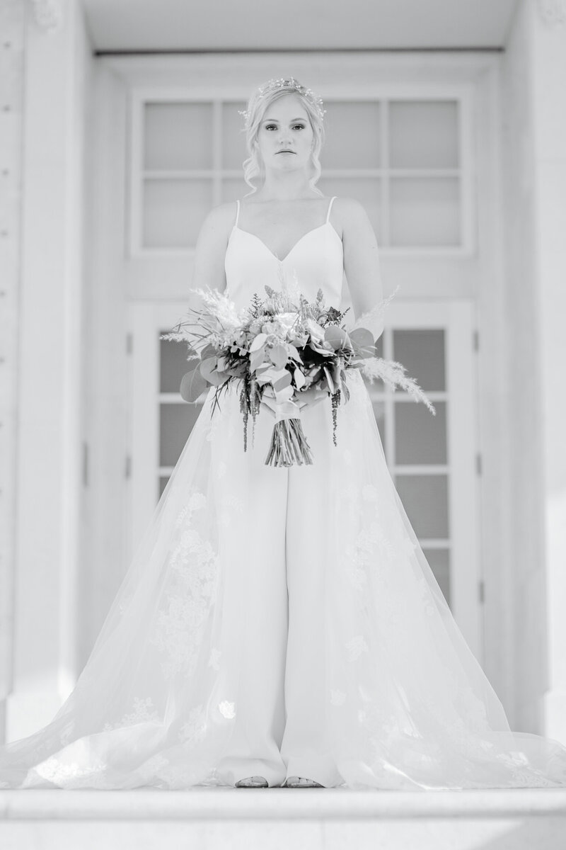 alt="bride on stairs the regent wedding"