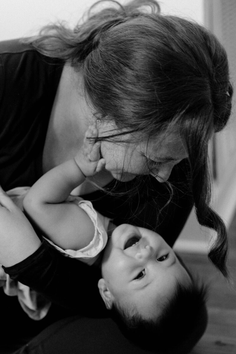 Olivia Yuen playing with her child, holding the baby and sharing a joyful moment.