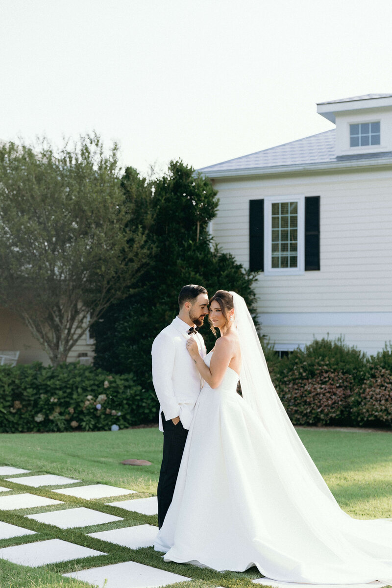 Wedding photoshoot on a green lawn, showcasing the intimate moments between the bride and groom