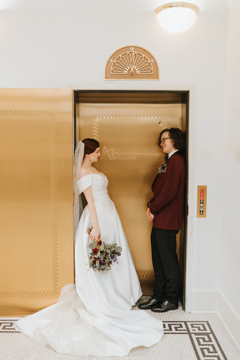 luxury wedding in art gallery, bride and groom standing in gold elevator doors