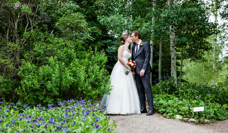 Stunning wedding photos at the Yampa River Botanic Park in Steamboat Springs with pretty purple flowers and green tree backdrop
