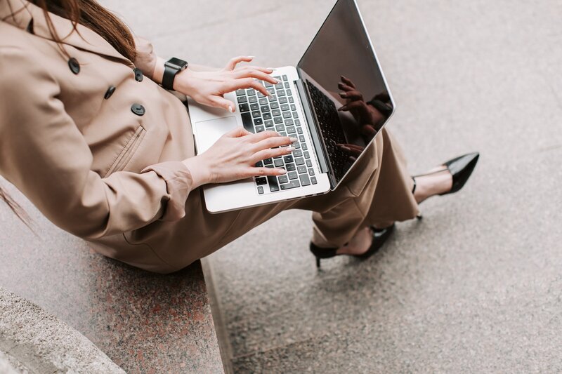 girl working on her laptop sitting on stairs