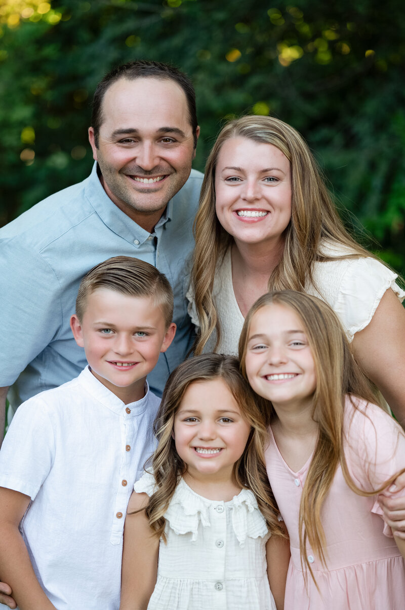 Family close together as they smile for the camera in Granite Bay, CA