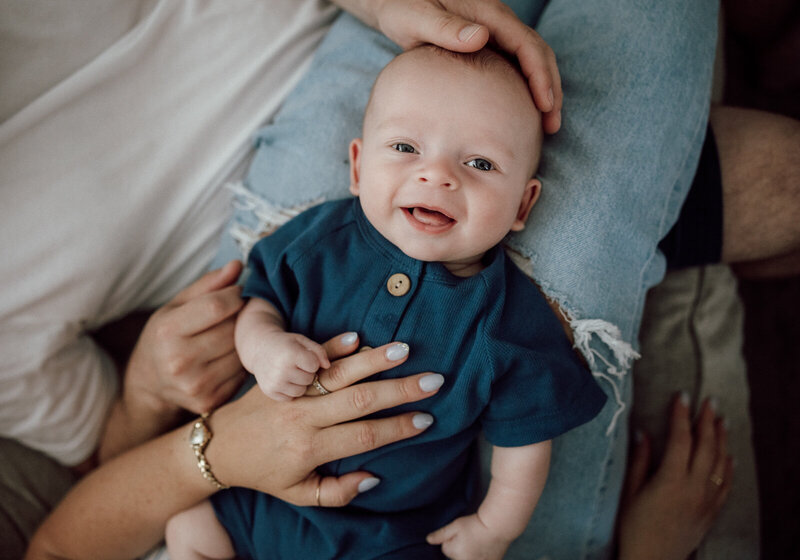 A baby smiling at the camera taken during a lifestyle in-home new born portrait session in St. Louis, Missouri. 