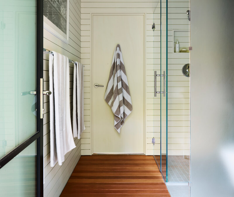 Kitchen bath designer Boston new construction home in Hingham modern features teak flooring, shiplap walls, and concrete flooring for a clean architectural look.
