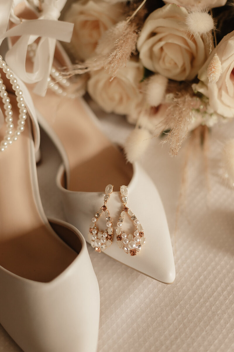 Bridal details of pearl earrings shoes and floral bouquet in Ottawa