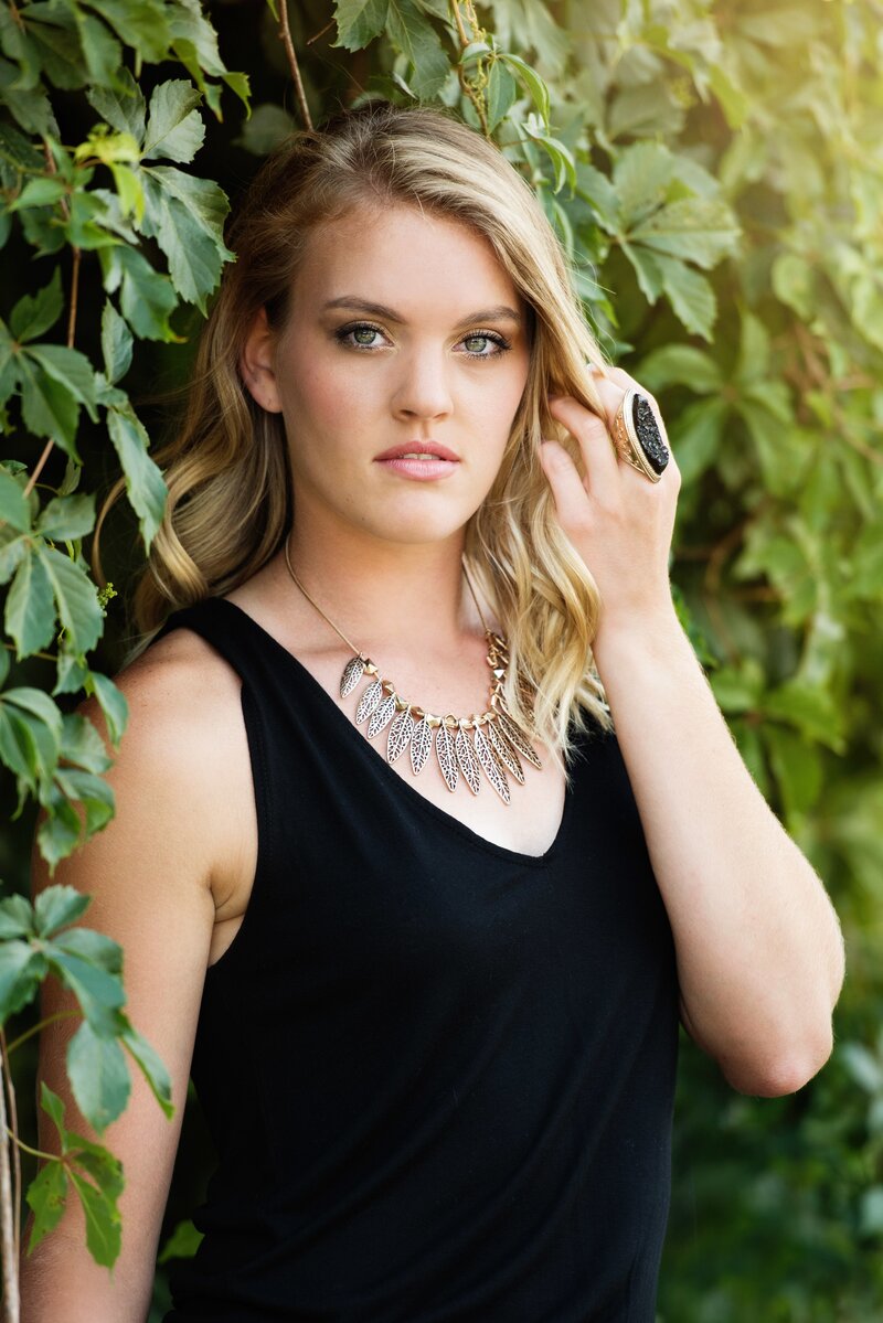 girl in black shirt with fun jewelry for senior shoot