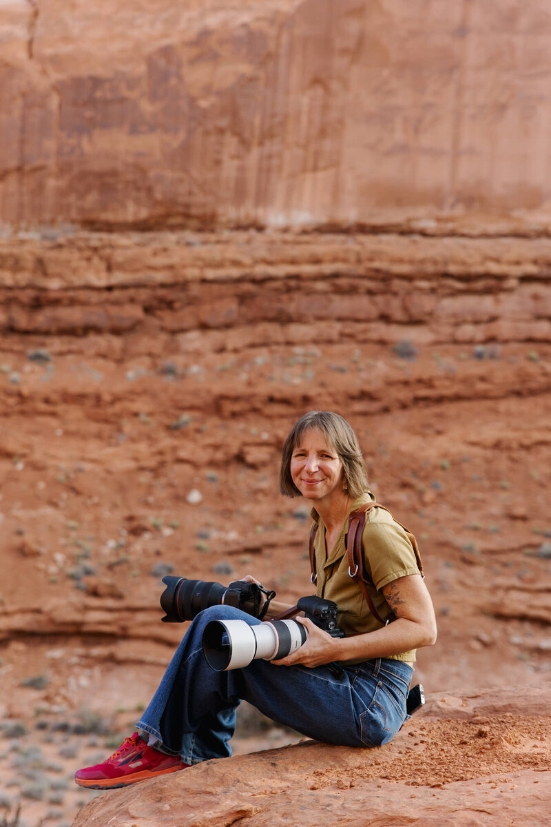 Aimee standing in front of the wave with her hands up in the air