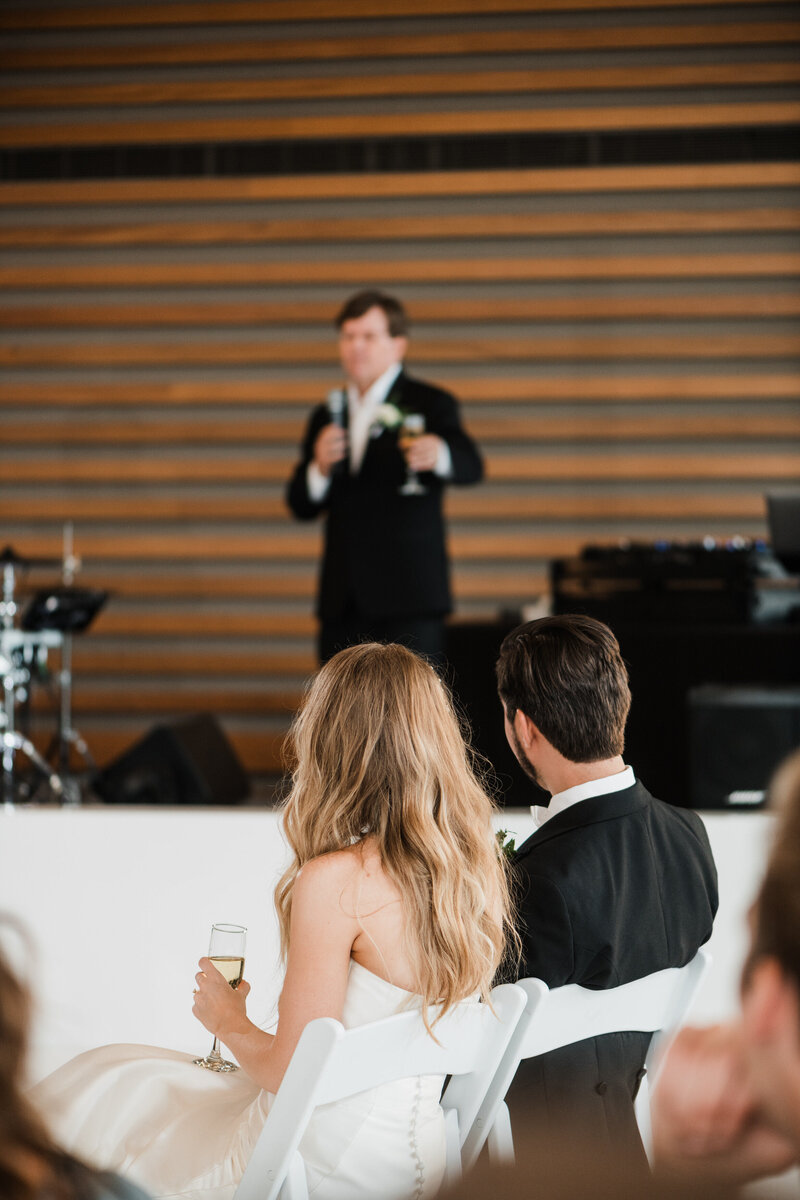 bride and groom listen to speeches