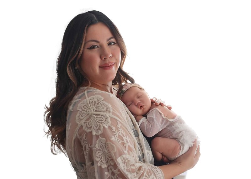 Momma holding her newborn against her chest at her newborn photography session.