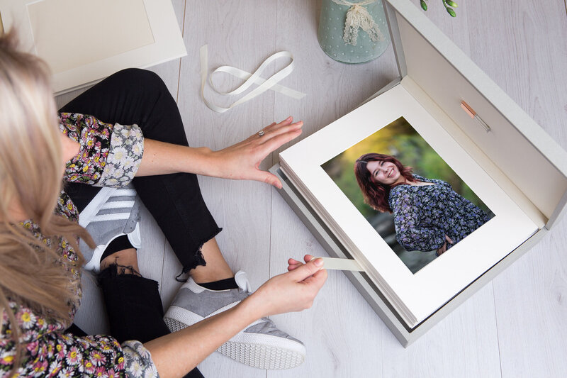 Mom sitting on floor opening professional portfolio box