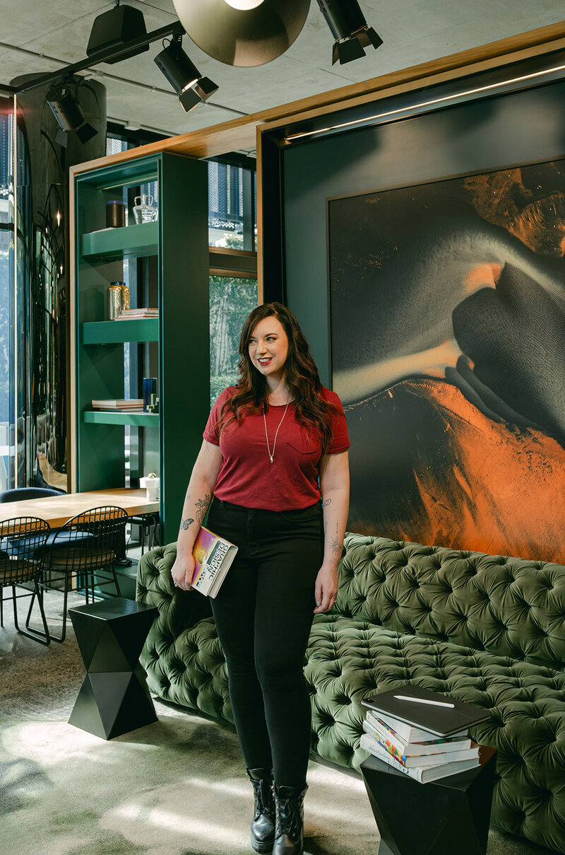 Website Designer brand photoshoot. Female sitting at table on her iPad.