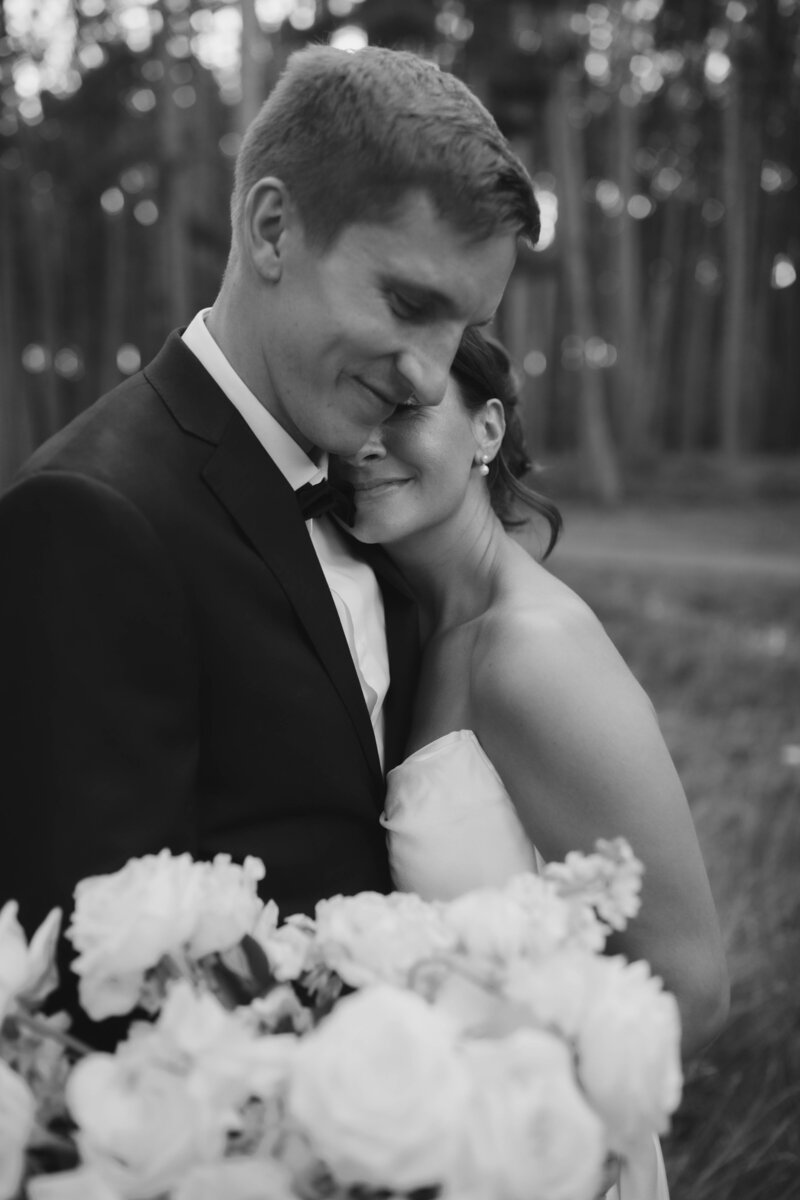 bride and groom holding flowers in black and white 