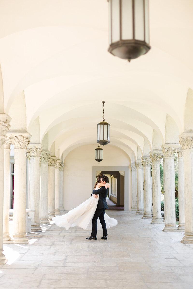 Groom picks up his bride and spins her around on their wedding day