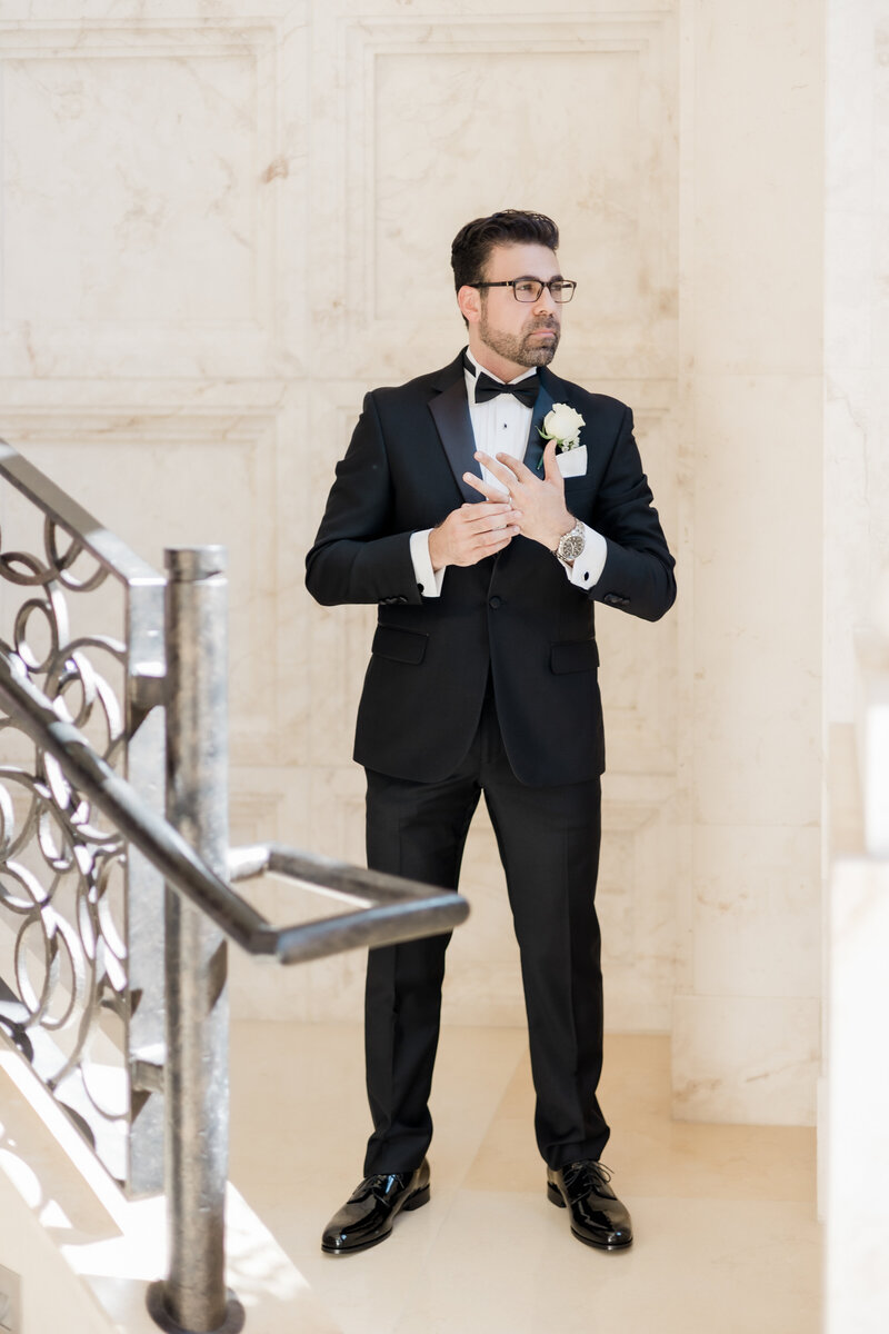 portrait of the groom by the staircase at a wedding at the four seasons Orlando by Florida wedding photographer.