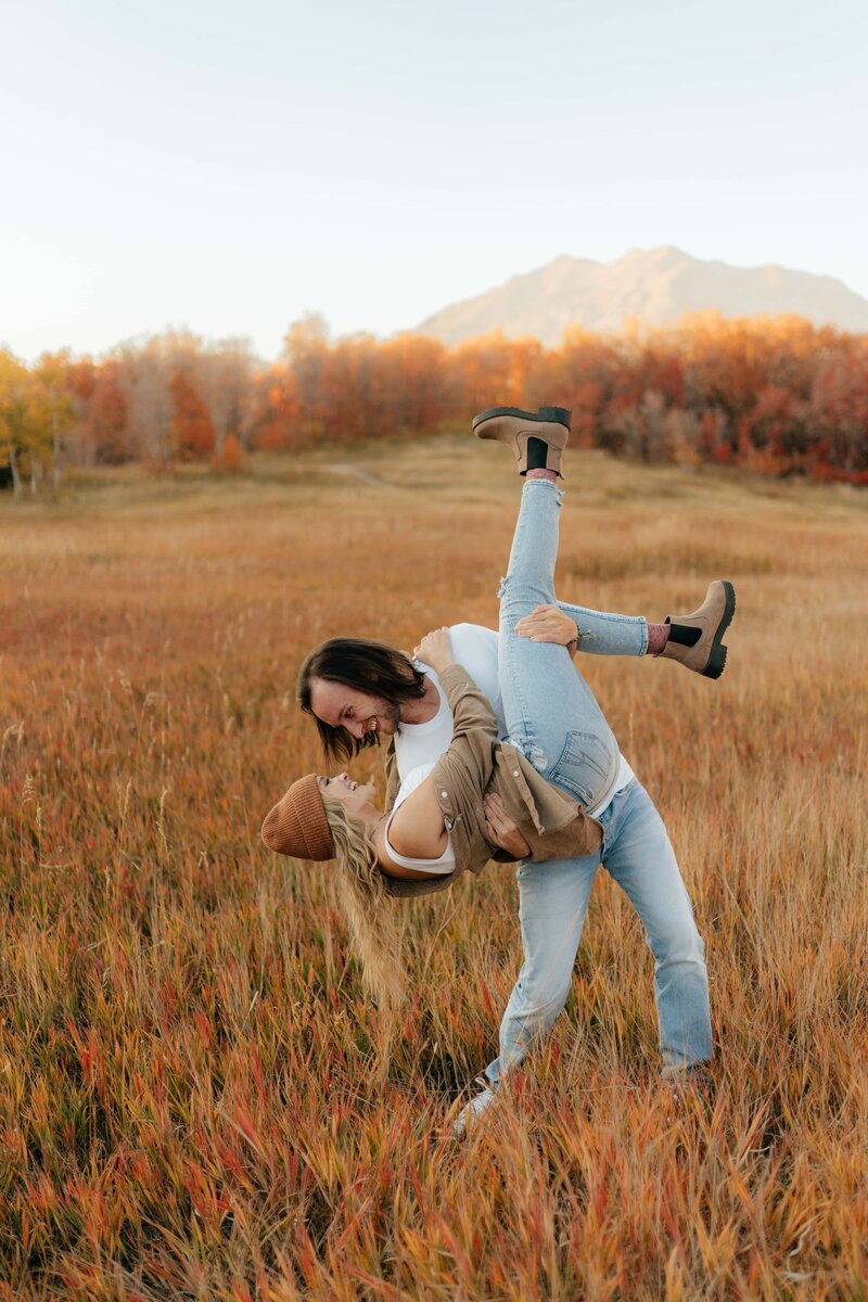 Man dipping women in grassy field in Provo Canyon in the fall