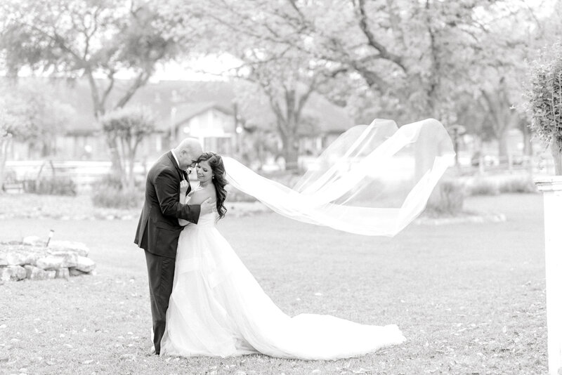bride and groom cuddling in field