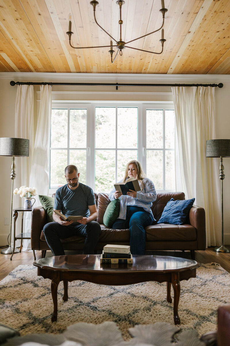 Laura-Anne and her husband sitting on a couch reading