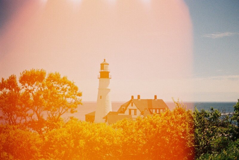 Iconic white Maine lighthouse standing tall against a clear blue sky