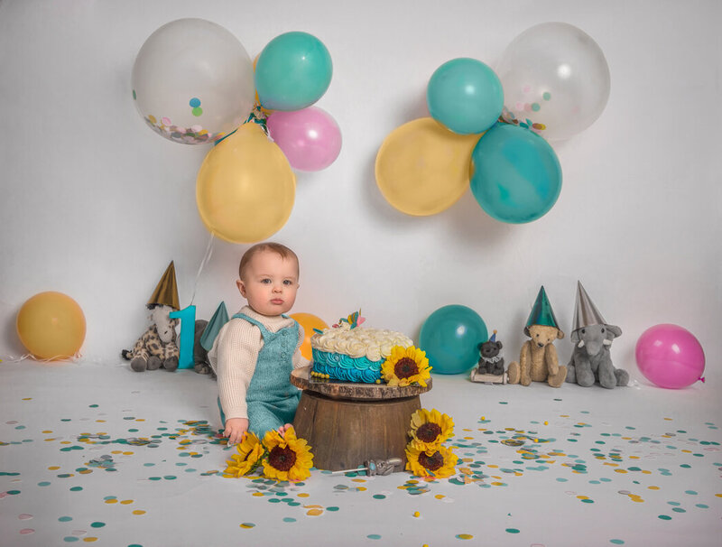 "Baby boy enjoying a blue-themed cake smash for his first birthday, captured in a joyful photography session in Ottawa."