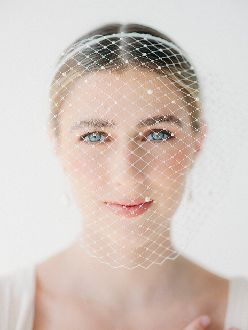 a woman wearing a wedding veil and looking into the camera