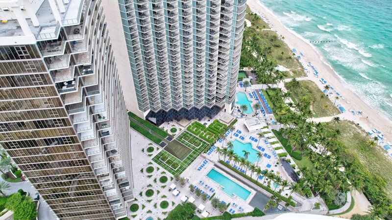 Aerial view of St. Regis Bal Harbour Center Tower with pools and beachfront, home to PH-888 penthouse