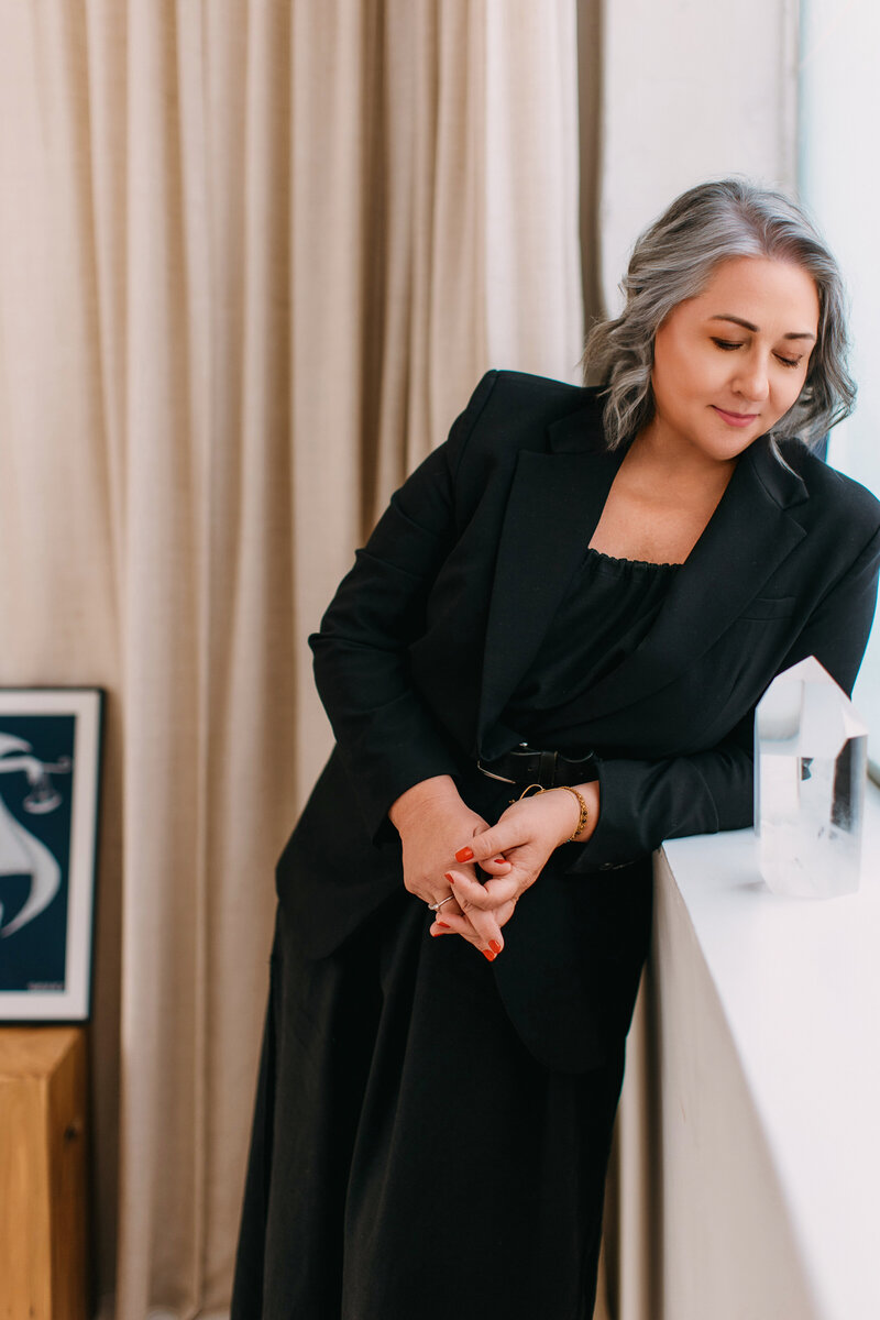 Astrocartographer Kristine Odegard looking at a crystal by the window